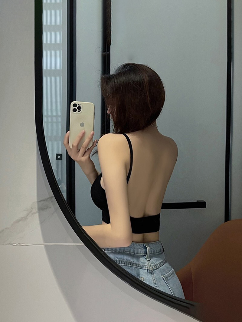 Ảnh chụp một người phụ nữ mặc áo hai ngực trước gương