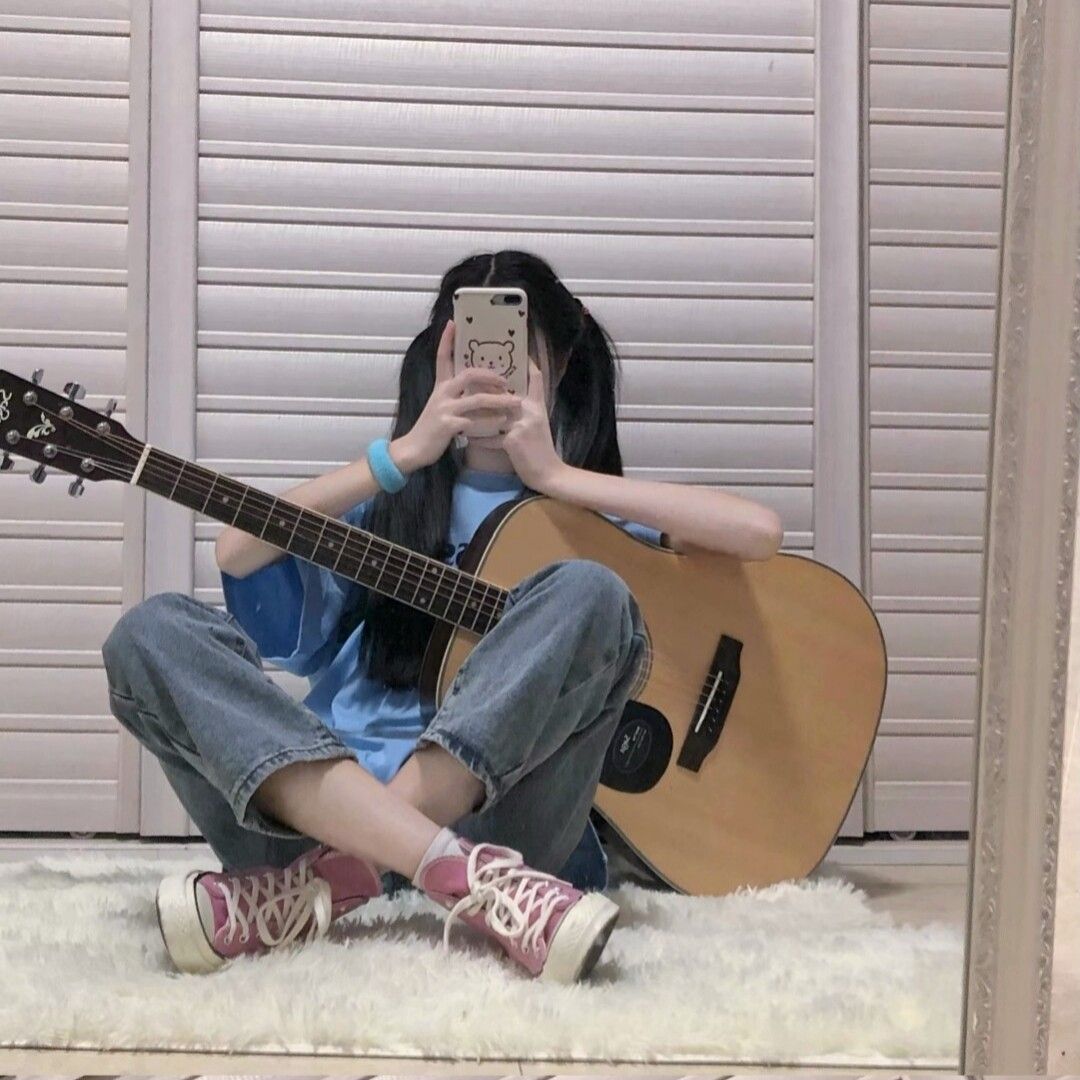 Hình ảnh nữ sinh trước gương, che mặt và cầm đàn guitar